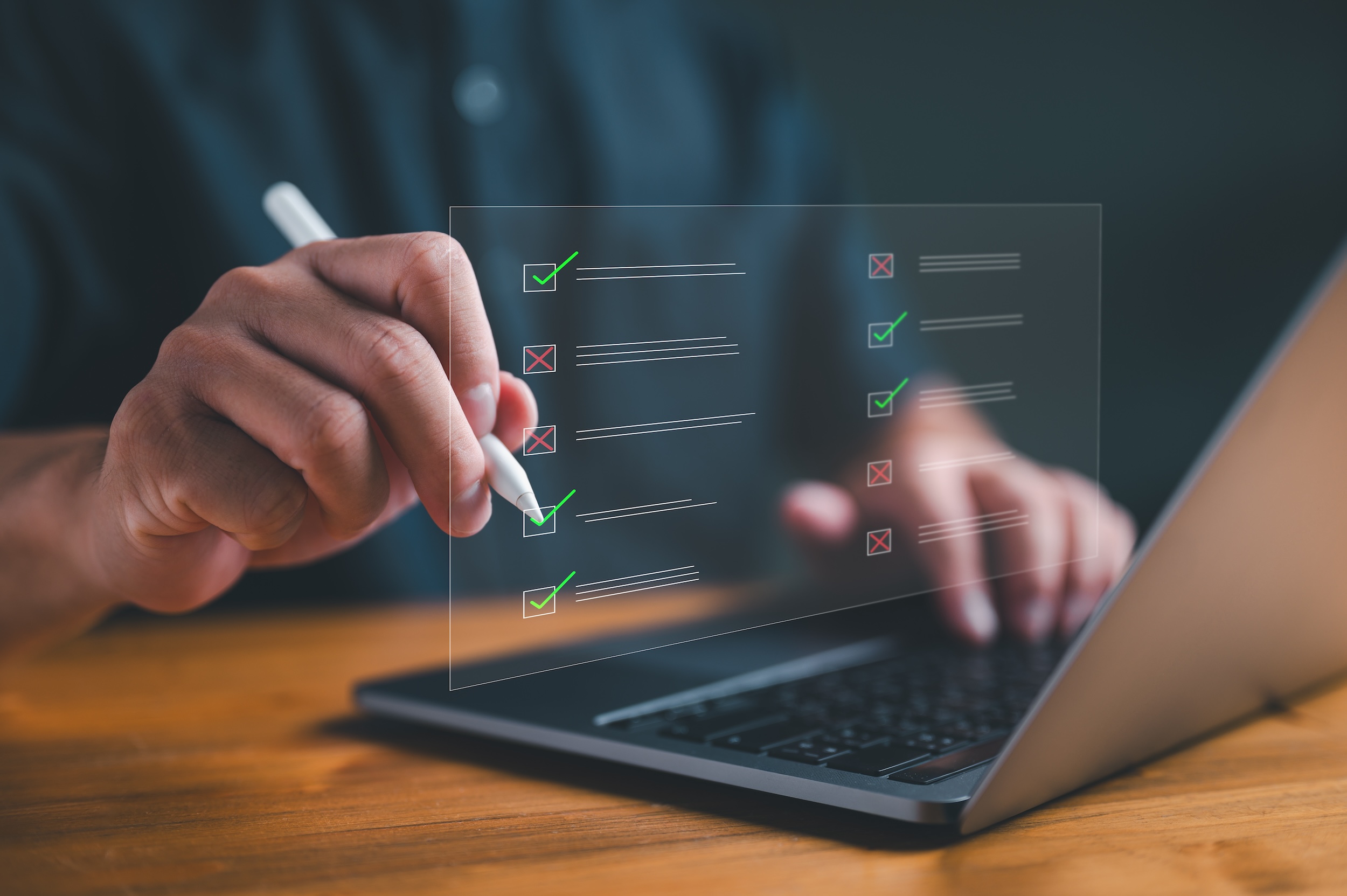 Businessman working on laptop computer with a compliance checklist and audit form.